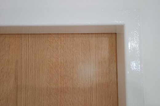 Lesklý nátěr bílé dveřní zárubně v rodinném domě Hvozdná
